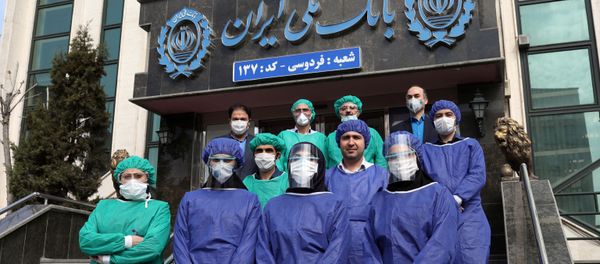 Bank employees wear protective face masks, following the outbreak of coronavirus, as they pose for a photo in Tehran, Iran March 17, 2020. Bank employees wear protective face masks, following the outbreak of coronavirus, as they pose for a photo in Tehran, Iran March 17, 2020. - Sputnik International