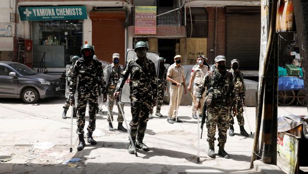 Paramilitary personnel and police officers stand guard on the street as India ordered a 21-day nationwide lockdown to limit the spreading of coronavirus disease (COVID-19), in New Delhi, India, March 25, 2020 - Sputnik International