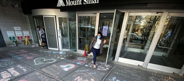 A woman exits Mount Sinai Hospital in Manhattan past messages of thanks written on the sidewalk during the outbreak of the coronavirus disease (COVID19) in New York City, New York, U.S., April 7, 2020.  - Sputnik International