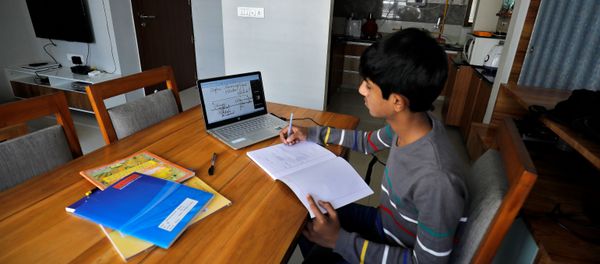 A student makes notes as he attends an online class at his home after Gujarat government ordered the closure of schools and colleges across the state amid coronavirus fears, in Ahmedabad, India, March 17,2020 - Sputnik International