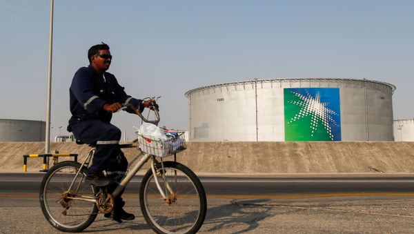 An employee rides a bicycle next to oil tanks at Saudi Aramco oil facility in Abqaiq, Saudi Arabia October 12, 2019. An employee rides a bicycle next to oil tanks at Saudi Aramco oil facility in Abqaiq, Saudi Arabia October 12, 2019. - Sputnik International