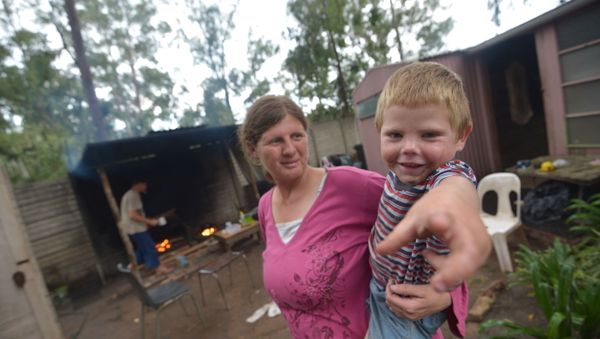 Marinda Labuschagne and her boy stand in front of their home with her husband cooking in the kitchen on a wood fire at a squatter camp for poor white South Africans at Coronation Park in Krugersdorp, on December 12, 2013 Marinda Labuschagne and her boy stand in front of their home with her husband cooking in the kitchen on a wood fire at a squatter camp for poor white South Africans at Coronation Park in Krugersdorp, on December 12, 2013 - Sputnik International