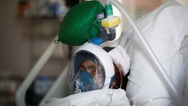 A patient suffering from coronavirus disease (COVID-19) wears a full-face Easybreath snorkelling mask given by sport chain Decathlon and turned into a ventilator for coronavirus treatment at the intensive care unit at Ambroise Pare clinic in Neuilly-sur-Seine near Paris, as the spread of the coronavirus disease continues in France, April 1, 2020. A patient suffering from coronavirus disease (COVID-19) wears a full-face Easybreath snorkelling mask given by sport chain Decathlon and turned into a ventilator for coronavirus treatment at the intensive care unit at Ambroise Pare clinic in Neuilly-sur-Seine near Paris, as the spread of the coronavirus disease continues in France, April 1, 2020. - Sputnik International