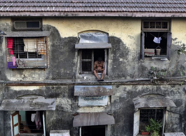 A man sits alone at the window of a Chawl during a lockdown to prevent the spread of the new coronavirus at Lower Parel area in Mumbai, India, Sunday, April 5, 2020.  - Sputnik International