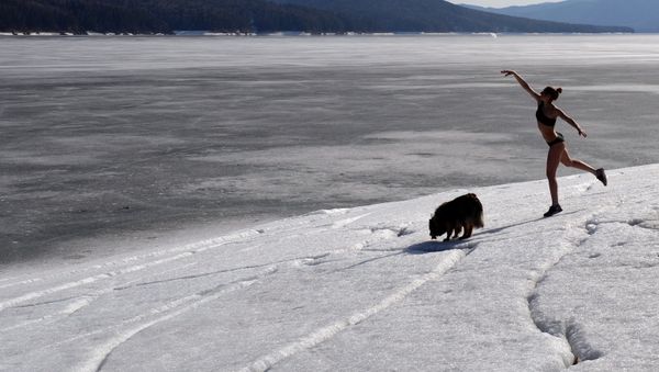 Yulia Boyarintseva, master of snowboarding and snowkiting sports, walks her dog near her home outside Krasnoyarsk - Sputnik International