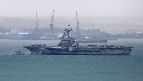 A picture taken on March 13, 2020, shows the French aircraft carrier Charles de Gaulle as it enters the port of Brest, in western France.  - Sputnik International