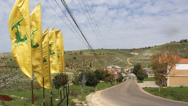Hezbollah flags flutter along an empty street, amid the coronavirus disease (COVID-19) outbreak, at the entrance of Mays Al-Jabal village, Lebanon March 26, 2020. - Sputnik International