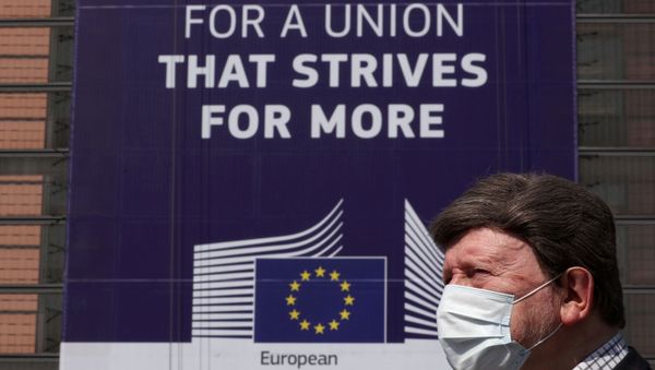 FILE PHOTO: A man wearing a face mask walks past the European Commission headquarters as the spread of coronavirus disease (COVID-19) continues in Brussels, Belgium April 9, 2020.  - Sputnik International