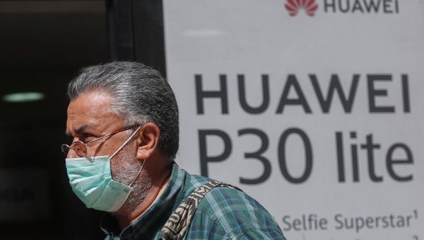 A man, wearing a protective mask due to the spread of coronavirus disease (COVID-19), walks past a Huawei store in Cairo, Egypt March 31, 2020. - Sputnik International