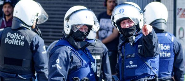 Belgian police officers wearing protective gears stand at the site of unrests in Anderlecht, Brussels, on April 11, 2020 Belgian police officers wearing protective gears stand at the site of unrests in Anderlecht, Brussels, on April 11, 2020 - Sputnik International