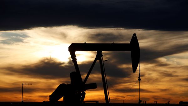 FILE PHOTO: The sun sets behind a crude oil pump jack on a drill pad in the Permian Basin in Loving County, Texas, U.S. November 24, 2019. Picture taken November 24, 2019. - Sputnik International
