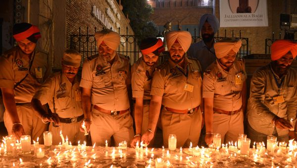 Indian Punjab Police personnel light candles as they pay tribute to the Jallianwala Bagh massacre martyrs on the eve of the 100th anniversary of the Jallianwala Bagh massacre, in Amritsar on April 12, 2019. - Sputnik International