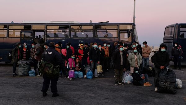 Migrants wearing protective face masks as a precaution against the spread of coronavirus disease (COVID-19), wait to board a ferry that will transfer them to the mainland, at the port of Mytilene on the island of Lesbos, Greece, March 20, 2020 - Sputnik International