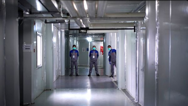 Security guards wearing face masks are seen near closed wards inside the Leishenshan Hospital, a makeshift hospital for treating patients with the coronavirus disease (COVID-19), in Wuhan, Hubei province, China April 11, 2020 - Sputnik International