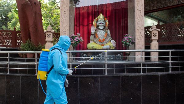 A health worker wearing protective gear sprays disinfectant at a crematorium to slow the spreading of the coronavirus disease (COVID-19), after India extended a nationwide lockdown to contain the disease, in New Delhi, India, April 14, 2020.  - Sputnik International