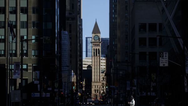 A pedestrian crosses the street with a dog during morning commuting hours in the Financial District as Toronto copes with a shutdown due to the Coronavirus, on April 1, 2020 in Toronto, Canada - Sputnik International