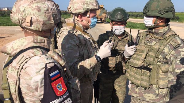 Soldiers of the Russian military police and the Turkish military during a joint patrol of the M-4 highway in Idlib province in Syria - Sputnik International