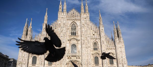 Pigeons fly over a deserted Piazza del Duomo in central Milan on 12 April 2020 during the country's lockdown aimed at curbing the spread of the COVID-19 infection, caused by the novel coronavirus. Pigeons fly over a deserted Piazza del Duomo in central Milan on 12 April 2020 during the country's lockdown aimed at curbing the spread of the COVID-19 infection, caused by the novel coronavirus. - Sputnik International