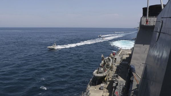 In this Wednesday, 15 April 2020, photo made available by the US Navy, Iranian Revolutionary Guard vessels sail close to US military ships in the Persian Gulf near Kuwait - Sputnik International
