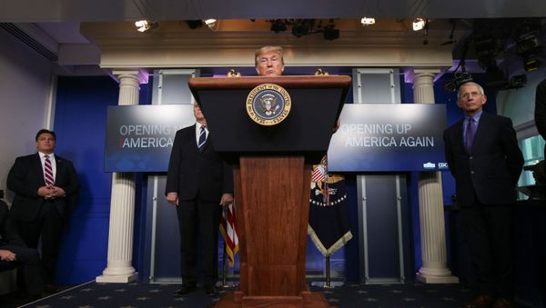 President Donald Trump announces the Trump administration's guidelines for Opening Up America Again as a U.S. Secret Service agent, Vice President Mike Pence and Dr Anthony Fauci look on during the daily coronavirus task force briefing at the White House in Washington, U.S., April 16, 2020 - Sputnik International