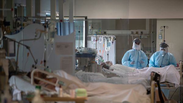 Healthcare workers attend to COVID-19 coronavirus patients at the Intensive Unit Care of the CEMTRO private clinic in Madrid on April 17, 2020. - Sputnik International