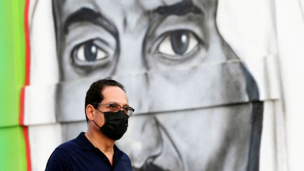 A Saudi man walks past a poster depicting Saudi King Salman bin Abdulaziz, after a curfew was imposed to prevent the spread of the coronavirus disease (COVID-19), in Riyadh, Saudi Arabia March 25, 2020 - Sputnik International