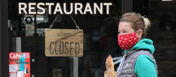 A woman wearing a protective face mask holds a French baguette as she walks past a closed restaurant in Cannes during a lockdown imposed to slow the rate of the coronavirus disease (COVID-19) in France, April 16, 2020 A woman wearing a protective face mask holds a French baguette as she walks past a closed restaurant in Cannes during a lockdown imposed to slow the rate of the coronavirus disease (COVID-19) in France, April 16, 2020 - Sputnik International