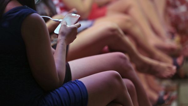 In this Thursday, June 19, 2014 photo, a sex worker checks her smartphone as she and others wait for customers in a brothel at Dolly prostitution complex in Surabaya, Indonesia. - Sputnik International