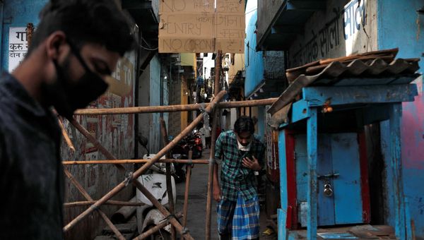 Men walk past a makeshift barricade that was set up to stop people from entering a lane, during a nationwide lockdown in India to slow the spread of COVID-19, in Dharavi, one of Asia's largest slums, during the coronavirus disease outbreak, in Mumbai, India, April 9, 2020 Men walk past a makeshift barricade that was set up to stop people from entering a lane, during a nationwide lockdown in India to slow the spread of COVID-19, in Dharavi, one of Asia's largest slums, during the coronavirus disease outbreak, in Mumbai, India, April 9, 2020 - Sputnik International