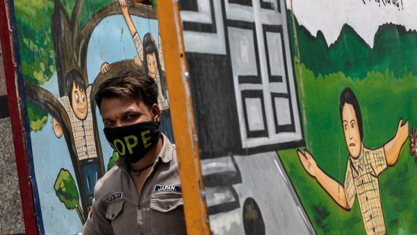 A resident waits to receive free food by government, during a nationwide lockdown to slow the spreading of the coronavirus disease (COVID-19), at a school in New Delhi, India, April 14, 2020. - Sputnik International