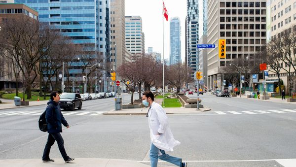 A health care worker runs across University Avenue from Mount Sinai Hospital to Toronto General Hospital as the number of the coronavirus disease (COVID-19) cases continues to grow in Toronto, Ontario, Canada April 17, 2020.  - Sputnik International