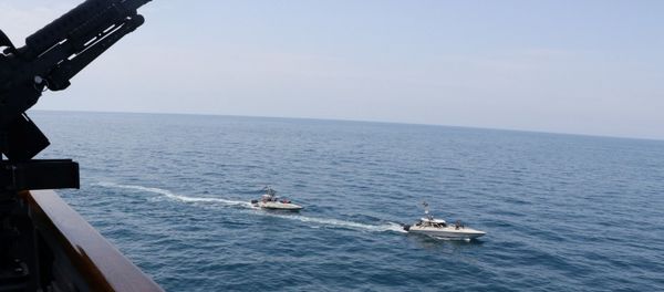 Two Iranian Islamic Revolutionary Guard Corps Navy (IRGCN) vessels, some of several to maneuver in what the U.S. Navy says are unsafe and unprofessional actions against U.S. Military ships by crossing the ships’ bows and sterns at close range is seen next to the guided-missile destroyer USS Paul Hamilton in the Gulf April 15, 2020 Two Iranian Islamic Revolutionary Guard Corps Navy (IRGCN) vessels, some of several to maneuver in what the U.S. Navy says are unsafe and unprofessional actions against U.S. Military ships by crossing the ships’ bows and sterns at close range is seen next to the guided-missile destroyer USS Paul Hamilton in the Gulf April 15, 2020 - Sputnik International
