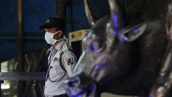 A security guard wearing a mask as a precaution against the new coronavirus stands at the Bombay Stock Exchange (BSE) building in Mumbai, in Mumbai, India, Monday, March 16, 2020 - Sputnik International
