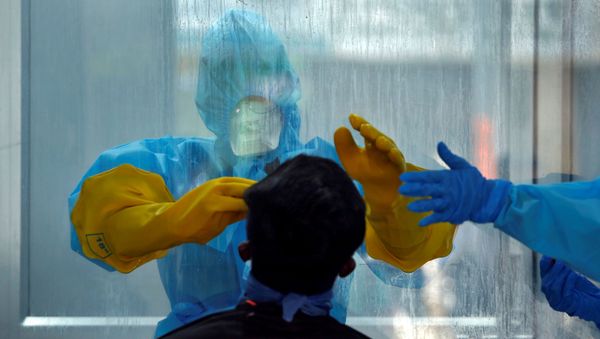A doctor in a protective chamber takes a swab from a man to test for coronavirus disease (COVID-19) in India - Sputnik International