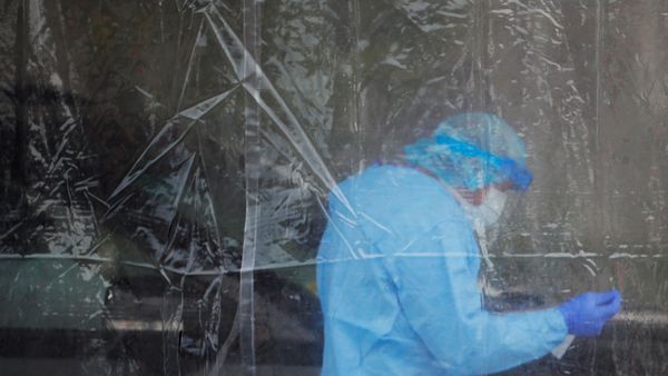 A healthcare worker administers a test for the coronavirus disease (COVID-19) at a drive-thru testing site in Providence, Rhode Island, U.S., April 23, 2020 - Sputnik International