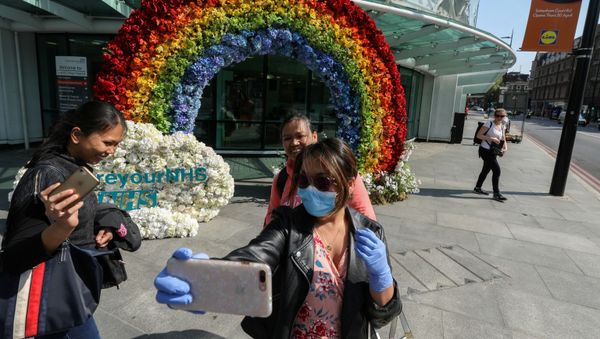 People take a selfie outside University College Hospital next to a rainbow flower display which was organised by the hospital workers to say thank you to the people for their support, during the outbreak of the coronavirus disease (COVID-19) in London, Britain, April 24, 2020. People take a selfie outside University College Hospital next to a rainbow flower display which was organised by the hospital workers to say thank you to the people for their support, during the outbreak of the coronavirus disease (COVID-19) in London, Britain, April 24, 2020. - Sputnik International