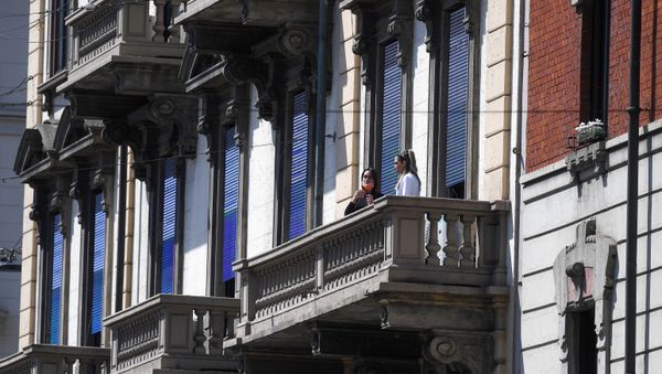 People wearing protective masks are pictured at a balcony during the coronavirus disease (COVID-19) outbreak, in Milan, Italy April 22, 2020. - Sputnik International