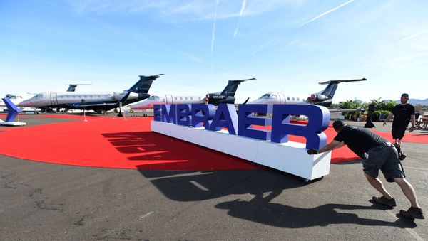 Workers set up at the Embraer booth prior to the opening of the National Business Aviation Association (NBAA) exhibition in Las Vegas, Nevada, U.S. October 21, 2019. - Sputnik International