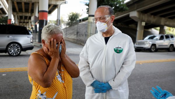 A homeless woman reacts next to a worker collecting samples during a Miami-Dade County testing operation for the coronavirus disease (COVID-19), in downtown Miami, Florida, U.S., April 16, 2020 A homeless woman reacts next to a worker collecting samples during a Miami-Dade County testing operation for the coronavirus disease (COVID-19), in downtown Miami, Florida, U.S., April 16, 2020 - Sputnik International