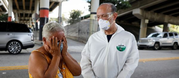 A homeless woman reacts next to a worker collecting samples during a Miami-Dade County testing operation for the coronavirus disease (COVID-19), in downtown Miami, Florida, U.S., April 16, 2020 A homeless woman reacts next to a worker collecting samples during a Miami-Dade County testing operation for the coronavirus disease (COVID-19), in downtown Miami, Florida, U.S., April 16, 2020 - Sputnik International