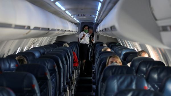 Flight attendants talk in a nearly empty cabin on a Delta Airlines flight operated by SkyWest Airlines as travel has cutback, amid concerns of the coronavirus disease (COVID-19), during a flight departing from Salt Lake City, Utah, U.S. April 11, 2020. - Sputnik International