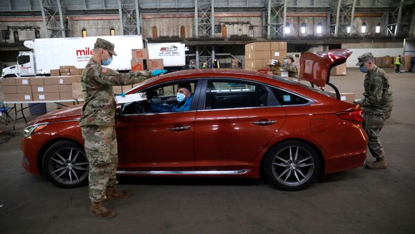 A US Army National Guard soldiers wear protective face masks while loading vehicles with food for delivery to residents in need at the Kingsbridge Armory which is being used as a temporary food distribution center during the outbreak of the coronavirus disease (COVID-19) in the Bronx borough of New York City, New York, U.S., April 21, 2020 - Sputnik International