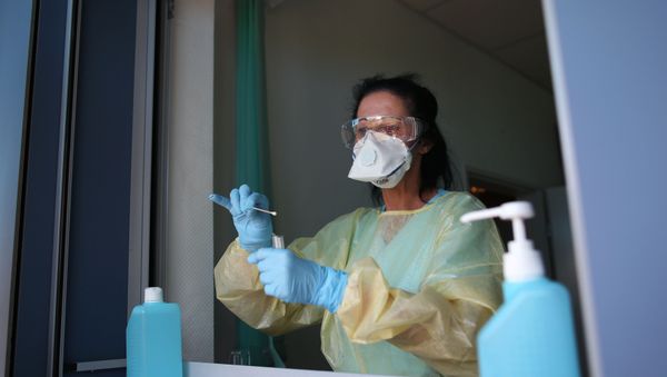 Nurse Sylke Pflugmacher takes a sample at a testing point for medical staff members at the community hospital in Magdeburg, eastern Germany, on 16 April 2020 during the novel coronavirus COVID-19 pandemic. Nurse Sylke Pflugmacher takes a sample at a testing point for medical staff members at the community hospital in Magdeburg, eastern Germany, on 16 April 2020 during the novel coronavirus COVID-19 pandemic. - Sputnik International