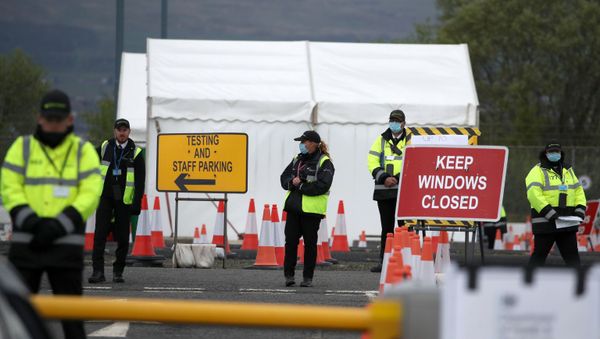 Staff direct traffic as key workers arrive for a test for the novel coronavirus Covid-19 at a drive-in testing centre at Glasgow Airport on April 29, 2020, as the UK continues in lockdown to help curb the spread of the coronavirus. - Sputnik International