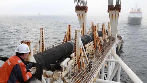 Picture taken on November 15, 2018 shows a man standing on the pipe-laying ship Audacia looking on as tubes are laid for the Nord Stream 2 gas pipeline off the coast of the Baltic Sea island Ruegen, northeastern Germany. - Sputnik International