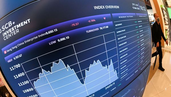 A man wearing a facemask amid concerns over the spread of the COVID-19 novel coronavirus, walks past a stock market display board showing movements of the Hong Kong's Hang Seng Index at a shopping mall in Bangkok on March 15, 2020. - Sputnik International