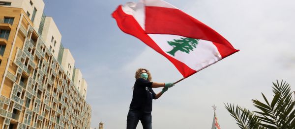 An anti-government demonstrator holds a Lebanese flag as she stands on top of her car, during a countrywide lockdown to combat the spread of the coronavirus disease (COVID-19), in Beirut, Lebanon April 21, 2020.  - Sputnik International