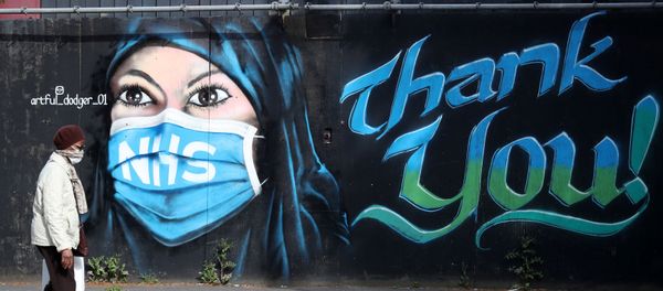 A person wearing a protective face mask walks past streetart ‘NHS Dedication Mural’ by The Artful Dodger (A.Dee) in Elephant & Castle, following the outbreak of the coronavirus disease (COVID-19), London, Britain, May 5, 2020 A person wearing a protective face mask walks past streetart ‘NHS Dedication Mural’ by The Artful Dodger (A.Dee) in Elephant & Castle, following the outbreak of the coronavirus disease (COVID-19), London, Britain, May 5, 2020 - Sputnik International