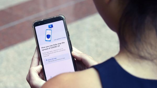 A Government Technology Agency (GovTech) staffer demonstrates Singapore's new contact-tracing smarthphone app called TraceTogether, as a preventive measure against the COVID-19 coronavirus in Singapore on 20 March 2020.  - Sputnik International