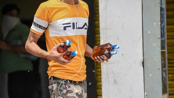 A man carries bottles of alcohol bought from a liquor shop after the government eased a nationwide lockdown imposed as a preventive mearure against the COVID-19 coronavirus, in Ghaziabad on May 6, 2020.  - Sputnik International
